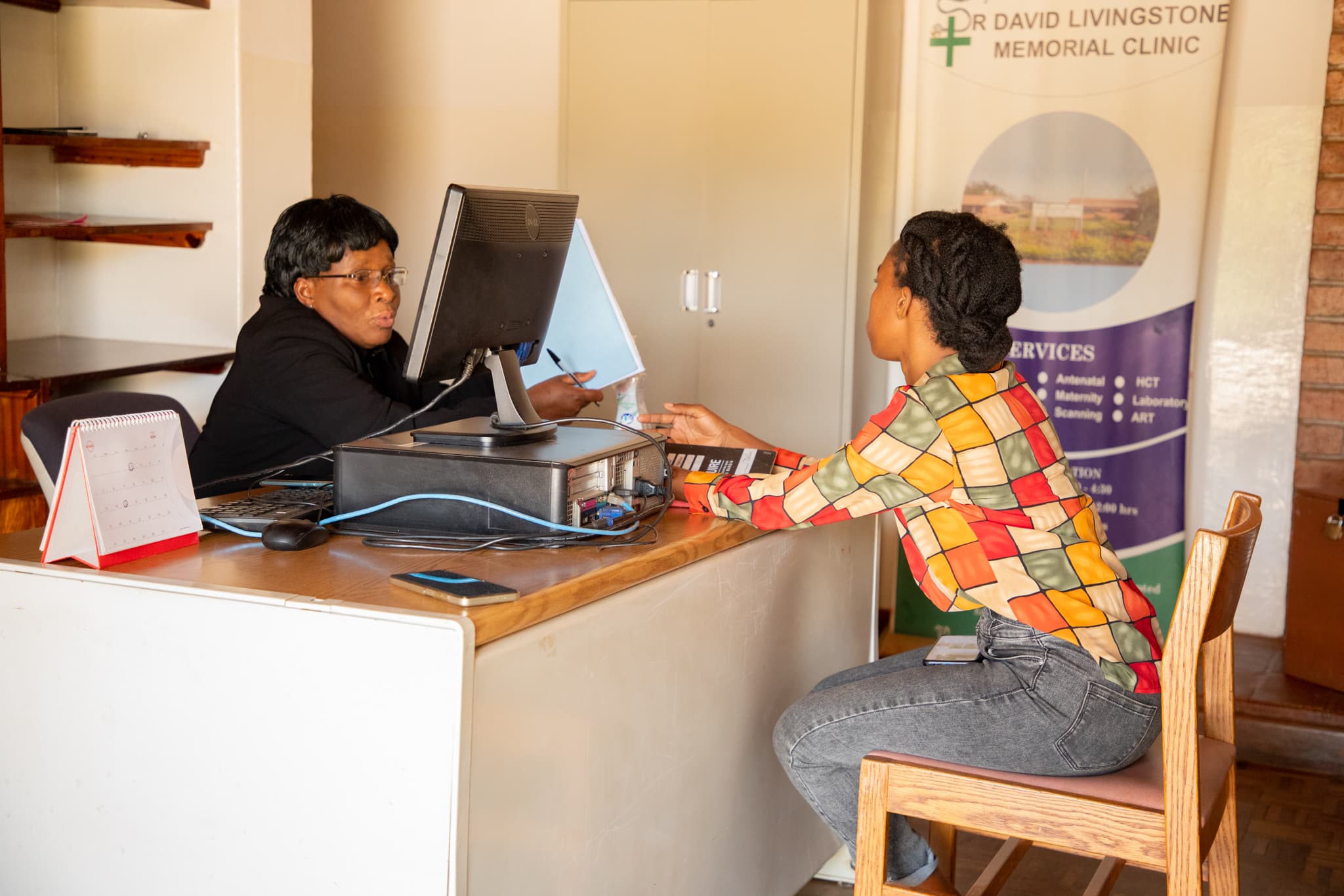 Healthcare worker consulting a member at a desk