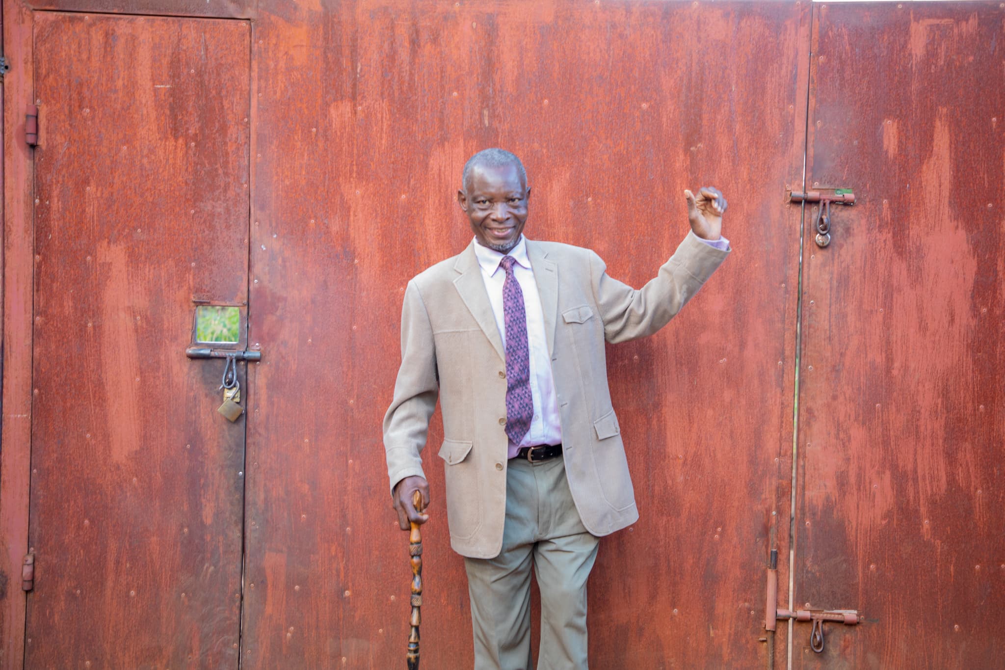 Retired member standing confidently near an office